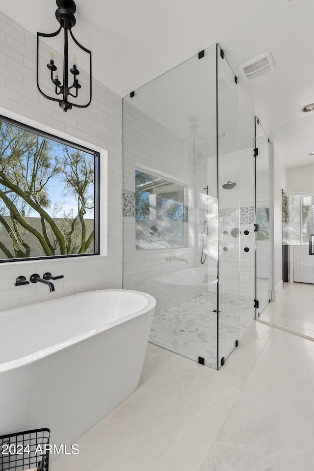 bathroom with a freestanding tub, visible vents, a chandelier, and a stall shower