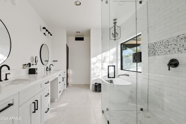 bathroom with a freestanding bath, a stall shower, a sink, and visible vents