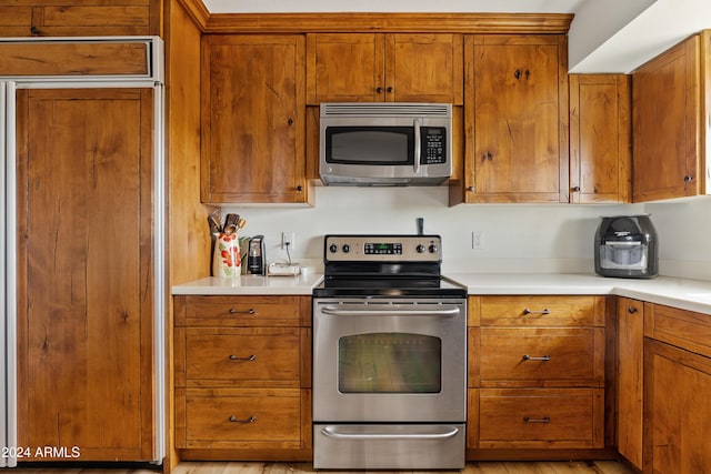 kitchen featuring light countertops, appliances with stainless steel finishes, and brown cabinets