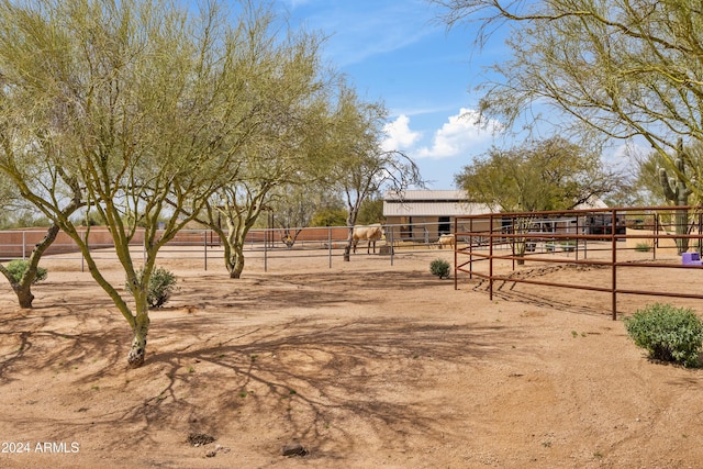 view of yard with an outbuilding, a rural view, and an exterior structure