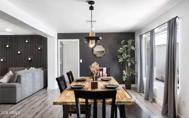 3330 E Cypress St, Phoenix, AZ 85008 - dining area featuring an accent wall, light wood-style floors, and baseboards