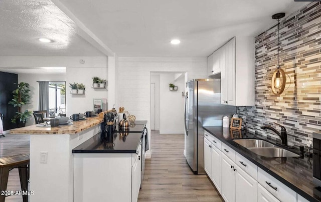 3330 E Cypress St, Phoenix, AZ 85008 - kitchen featuring a sink, a breakfast bar, light wood finished floors, white cabinets, and decorative backsplash