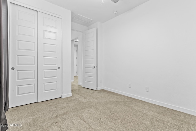 unfurnished bedroom featuring a closet and light carpet