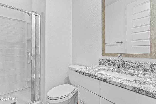 bathroom with a shower with door, vanity, and toilet