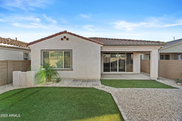 rear view of house featuring a yard and a patio area