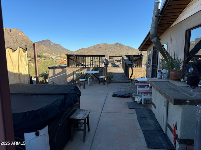 view of patio / terrace with grilling area, exterior bar, and a deck with mountain view