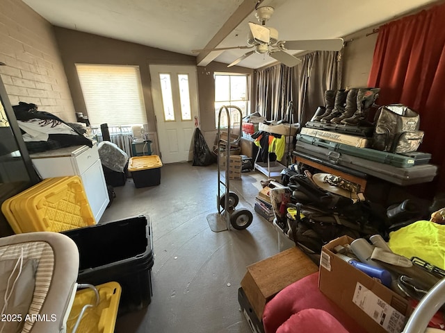 miscellaneous room with ceiling fan, vaulted ceiling with beams, and brick wall