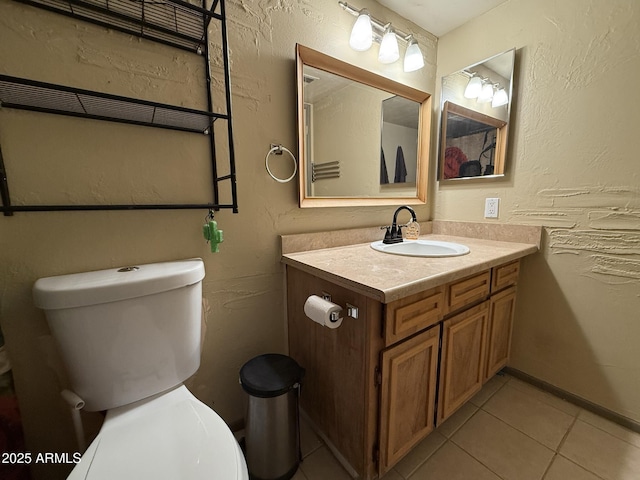 bathroom featuring toilet, tile patterned flooring, and vanity