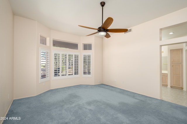 carpeted spare room with ceiling fan