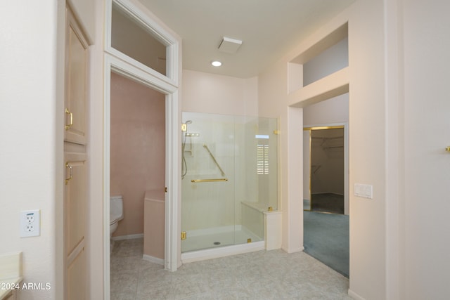 bathroom featuring tile patterned floors, toilet, and walk in shower