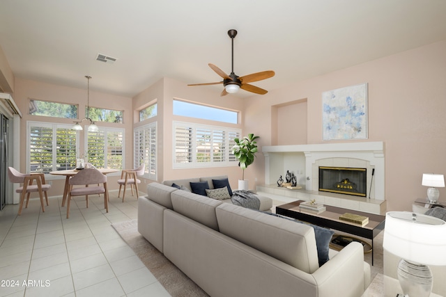 tiled living room featuring a fireplace, plenty of natural light, and ceiling fan