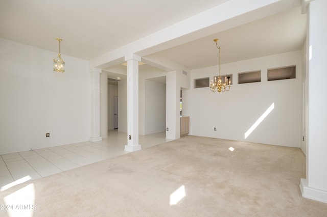 carpeted spare room with decorative columns and a notable chandelier