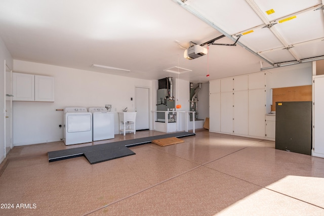 garage with independent washer and dryer, heating unit, and a garage door opener