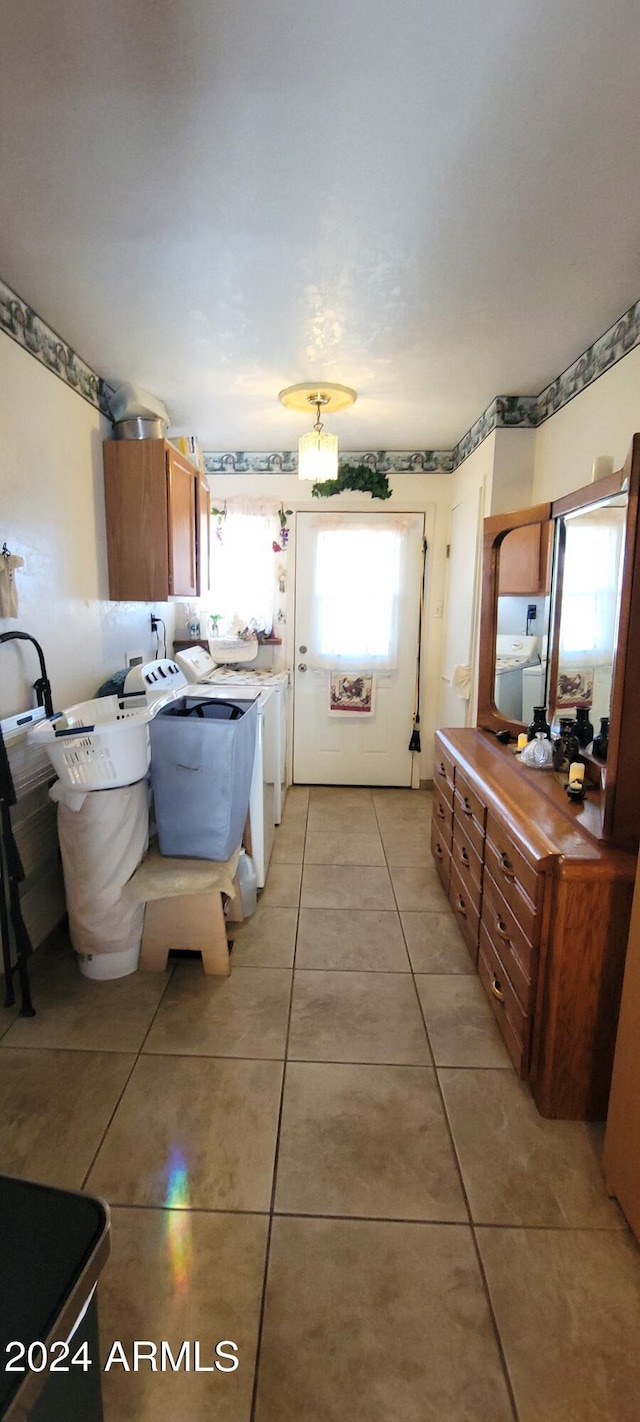 interior space featuring washer and clothes dryer, light tile patterned floors, and a wealth of natural light