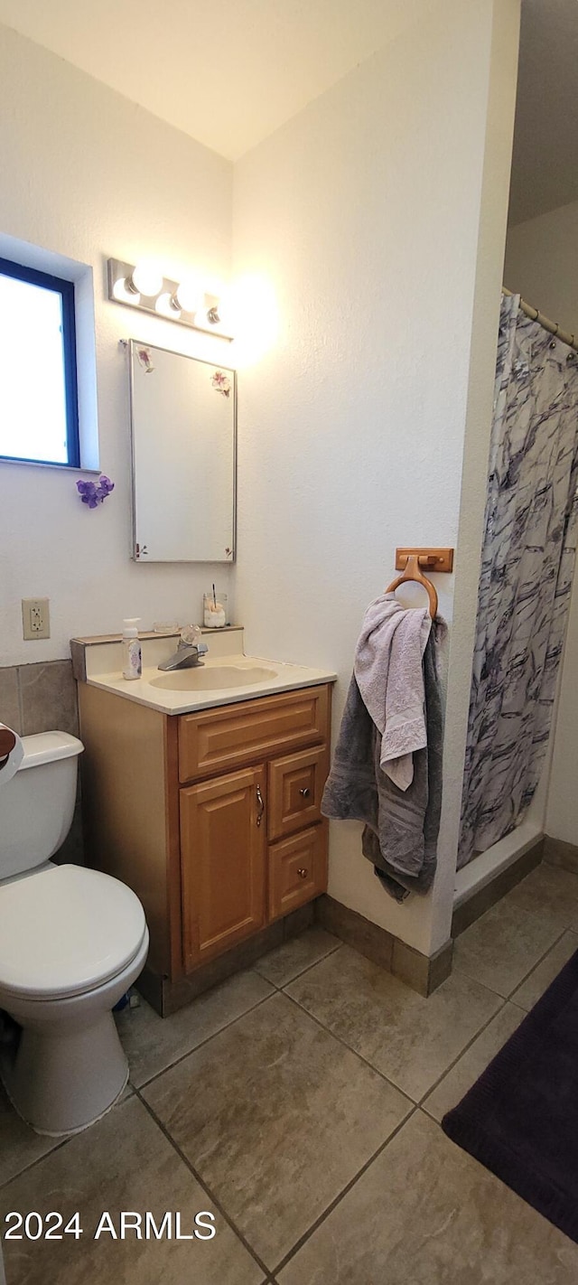 bathroom featuring tile patterned floors, vanity, a shower with shower curtain, and toilet