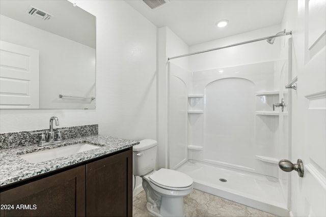 bathroom featuring vanity, toilet, and a shower