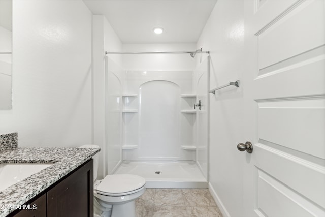 bathroom with vanity, toilet, and a shower