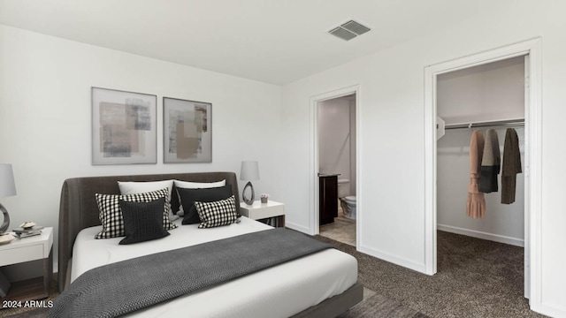 bedroom featuring ensuite bath, a closet, and dark colored carpet