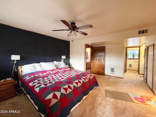 bedroom with connected bathroom, ceiling fan, and light carpet