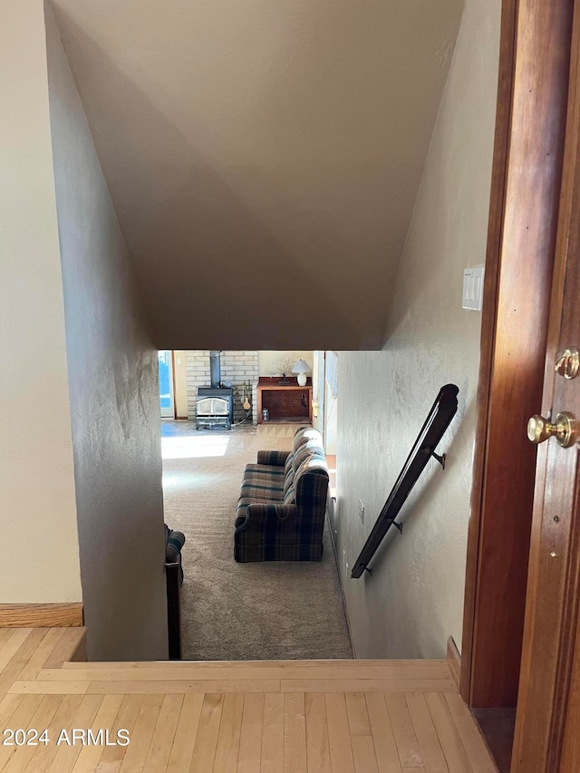 stairway featuring lofted ceiling and hardwood / wood-style floors