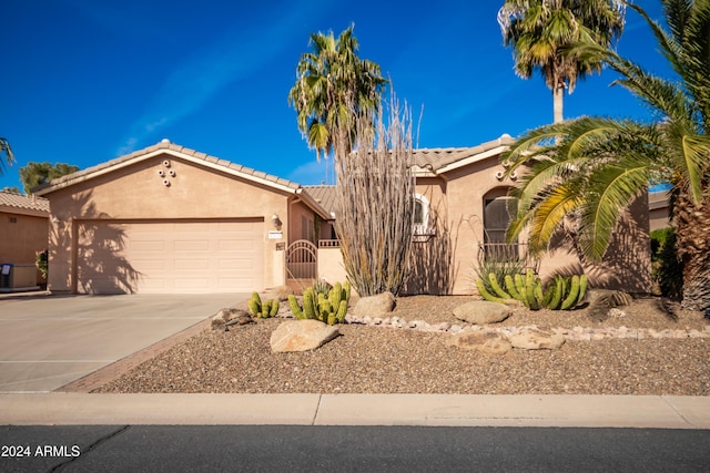 view of front of house featuring a garage, driveway, a tiled roof, and stucco siding