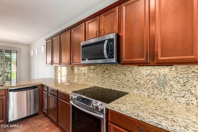 kitchen with light stone countertops, tasteful backsplash, and stainless steel appliances