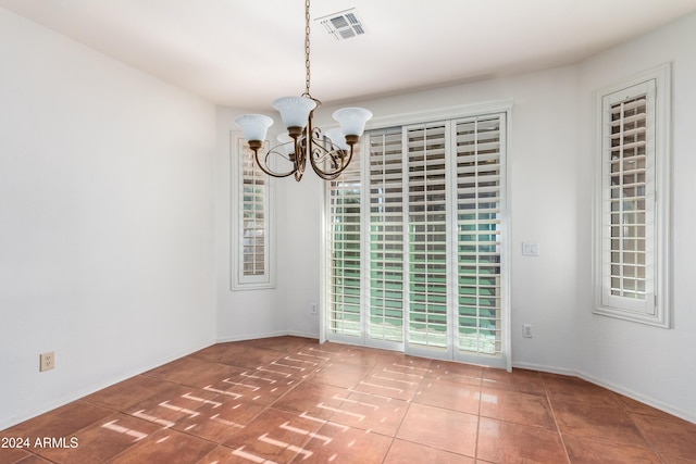 unfurnished room featuring baseboards, tile patterned floors, visible vents, and an inviting chandelier