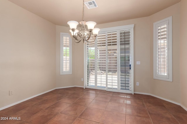 unfurnished room featuring an inviting chandelier and tile patterned floors