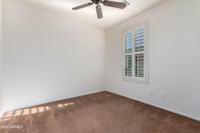 spare room with carpet floors, visible vents, baseboards, and a ceiling fan