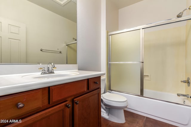 bathroom with bath / shower combo with glass door, vanity, toilet, and tile patterned floors