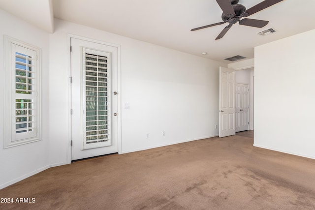 unfurnished room with baseboards, ceiling fan, visible vents, and carpet flooring