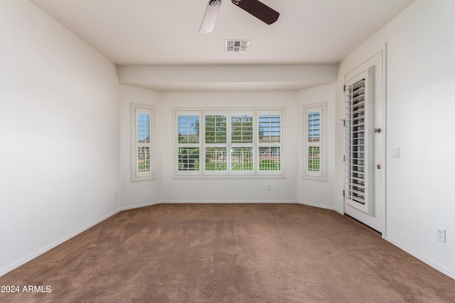 carpeted empty room featuring visible vents, ceiling fan, and baseboards