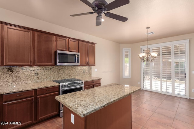 kitchen featuring appliances with stainless steel finishes, decorative light fixtures, backsplash, light stone counters, and light tile patterned flooring