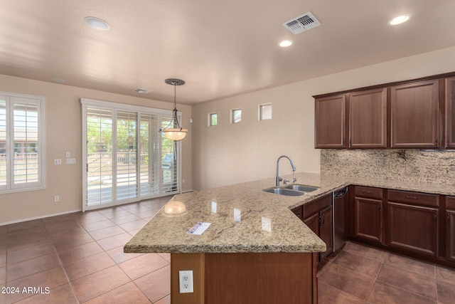 kitchen with backsplash, light stone countertops, light tile patterned floors, sink, and kitchen peninsula