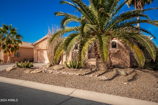 view of front of property with a garage, a tile roof, and stucco siding