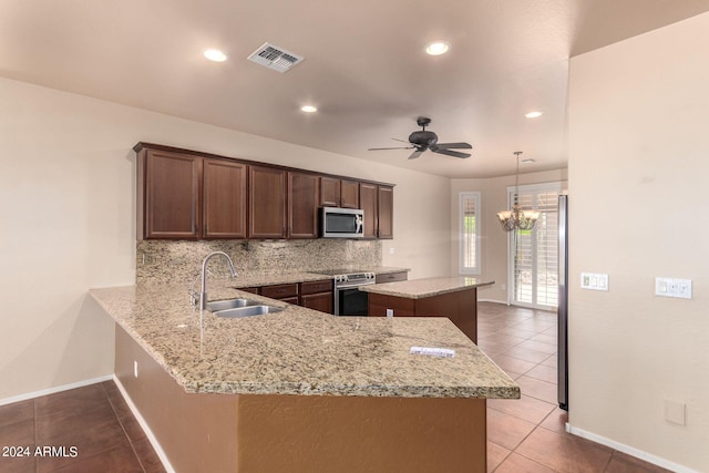 kitchen with tile patterned flooring, ceiling fan with notable chandelier, sink, kitchen peninsula, and stainless steel appliances