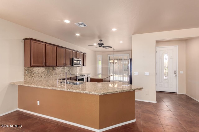 kitchen featuring sink, light stone counters, tasteful backsplash, ceiling fan, and stainless steel appliances