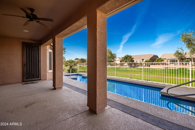 view of swimming pool with a patio, a lawn, a hot tub, a ceiling fan, and fence