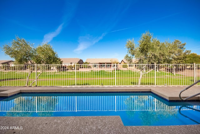 view of pool featuring a lawn, a residential view, fence, and a fenced in pool