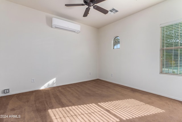 empty room featuring a wealth of natural light, an AC wall unit, visible vents, and carpet flooring