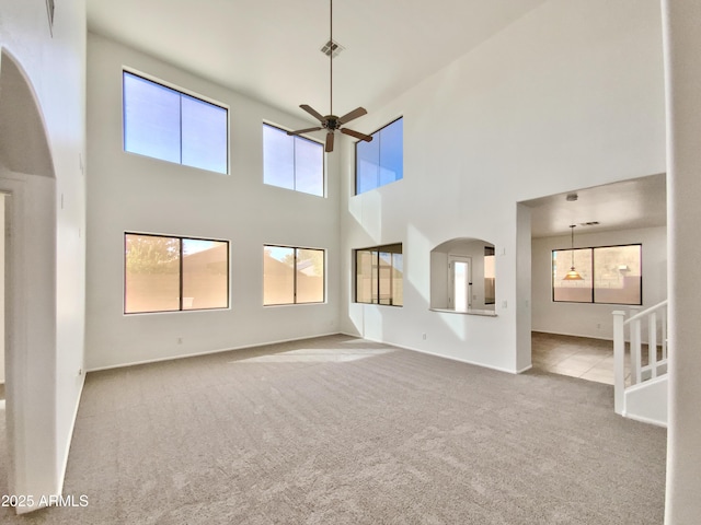 1274 W Dexter Way, San Tan Valley, AZ 85143 - unfurnished living room with baseboards, arched walkways, carpet, a ceiling fan, and a high ceiling
