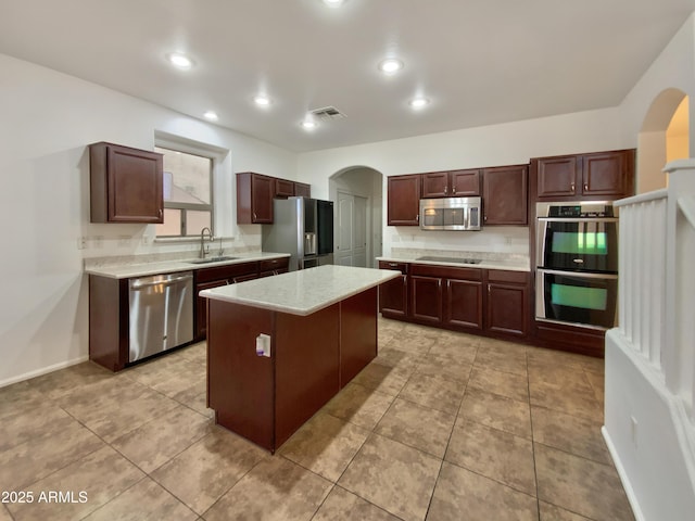 1274 W Dexter Way, San Tan Valley, AZ 85143 - kitchen with a sink, a center island, light countertops, arched walkways, and appliances with stainless steel finishes