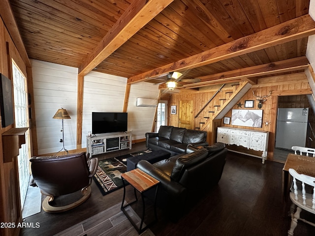 living area featuring dark wood-style flooring, stairway, beamed ceiling, and wooden walls
