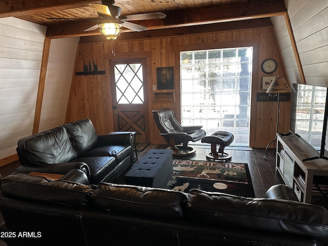 living room with wood ceiling, wooden walls, wood finished floors, beamed ceiling, and ceiling fan
