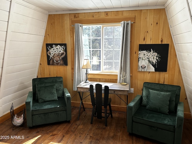 sitting room with hardwood / wood-style flooring, wood walls, and baseboards