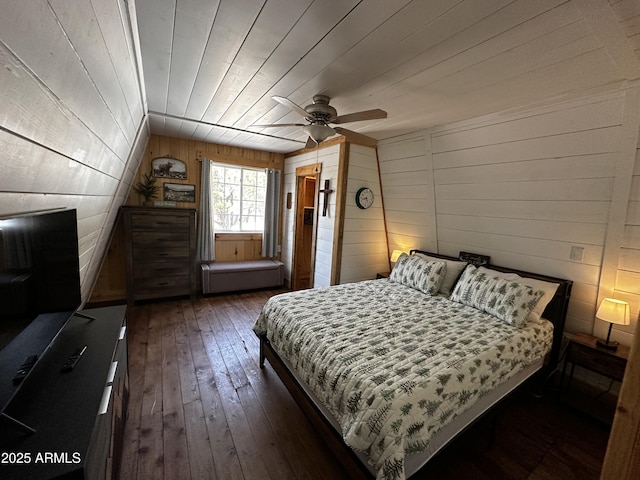 bedroom with dark wood-style floors, wooden ceiling, wood walls, and a ceiling fan