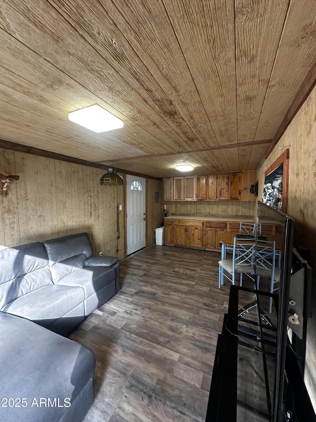 living area featuring dark wood finished floors, wooden walls, and wood ceiling