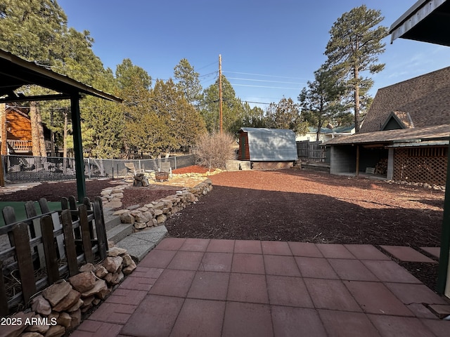 view of patio / terrace featuring a fenced backyard, a storage unit, and an outdoor structure