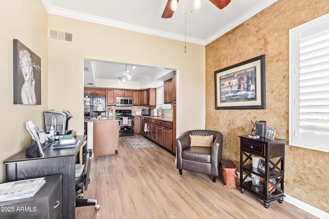 living area with a tray ceiling, light wood-style flooring, visible vents, and crown molding