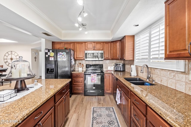 kitchen featuring a sink, visible vents, black appliances, a tray ceiling, and crown molding